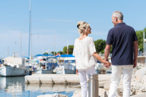 A man and woman holding hands walking along the marina signifying a healthy sexual relationship.